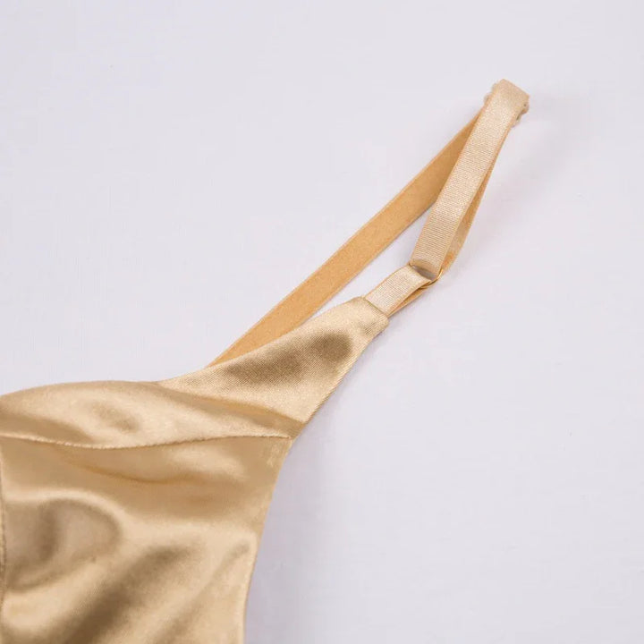 Close-up of beige satin fabric and adjustable strap on women’s camisole top