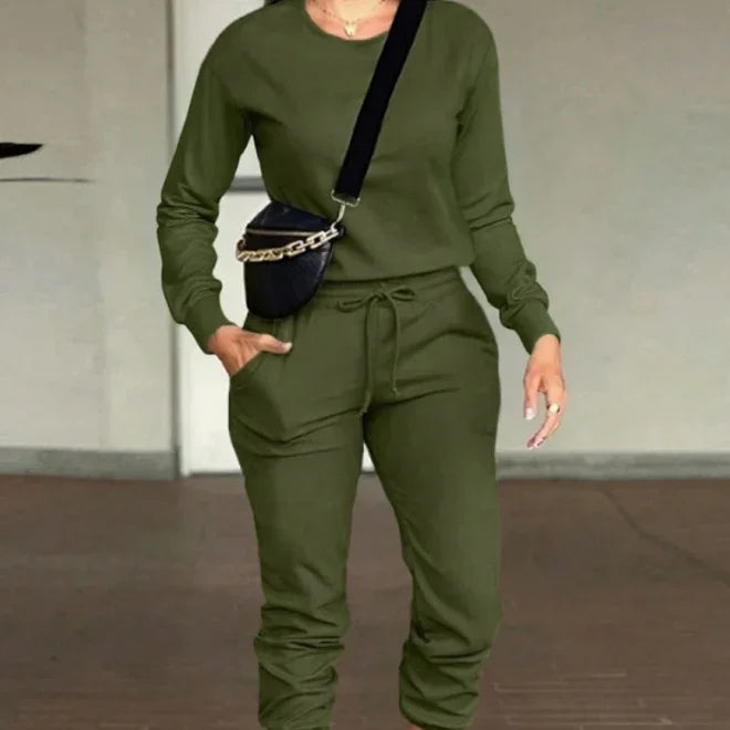 Woman wearing olive green casual long-sleeve top and matching joggers with black crossbody bag