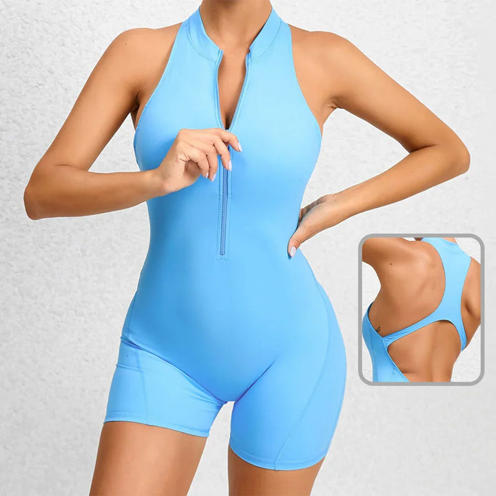 Woman wearing light blue sleeveless zip-up romper with racerback design and shorts