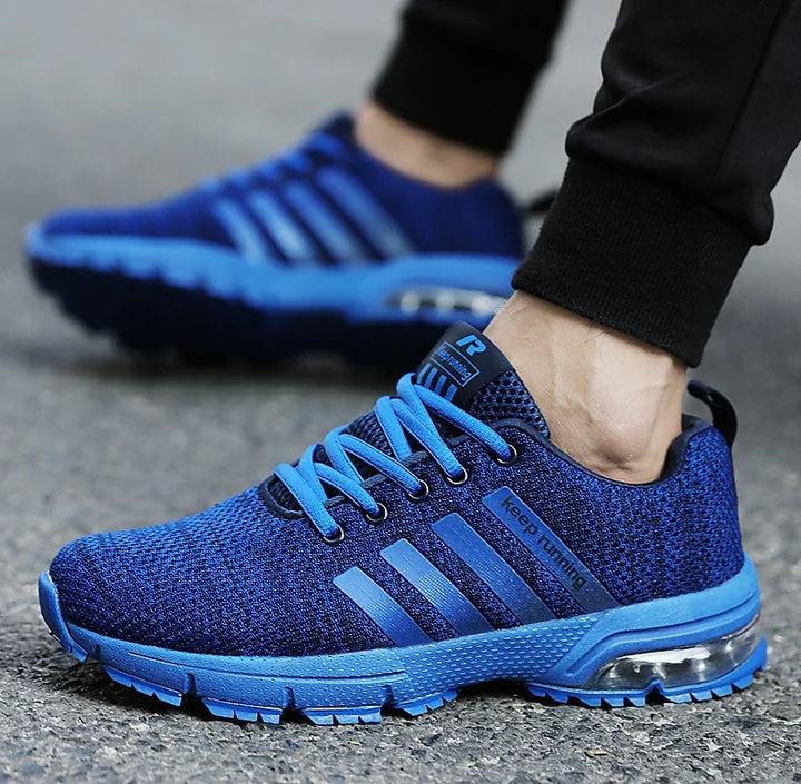 blue running shoes with air cushion sole and mesh fabric worn on asphalt road