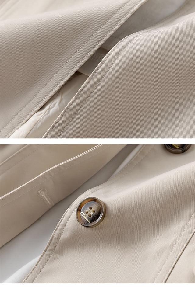 Close-up of beige tailored coat with brown glossy buttons and fine stitching details