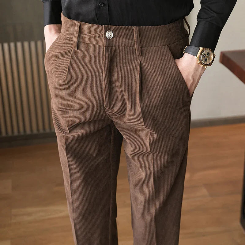 Close-up of brown corduroy pants with pockets worn with a black shirt and gold wristwatch