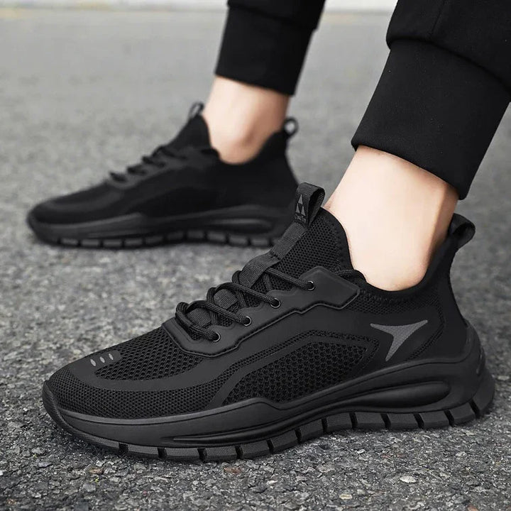 black lightweight mesh running sneakers with cushioned sole on asphalt surface
