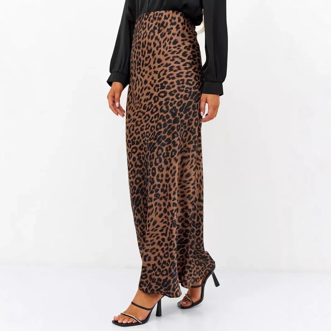 Woman wearing a leopard print maxi skirt and black strappy high heels on white background