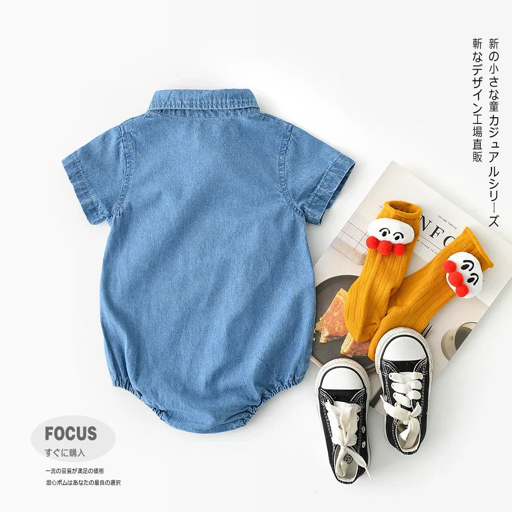 Blue denim baby romper with short sleeves, paired with mustard cartoon socks and black baby sneakers