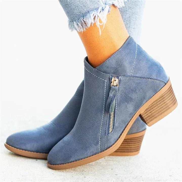 blue suede ankle boots with tan stacked heel and side zipper, worn with frayed light gray jeans