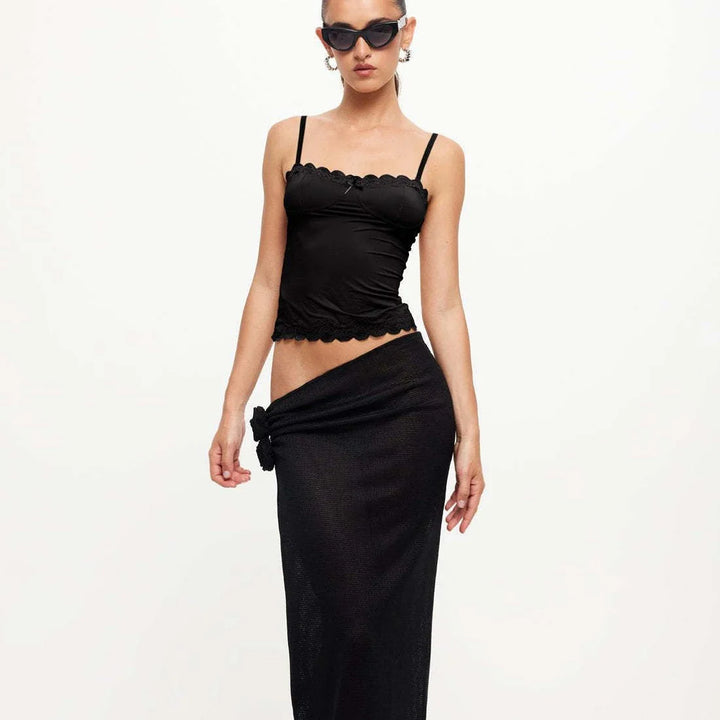 Woman wearing black lace-trim camisole and long black sarong skirt with knot detail