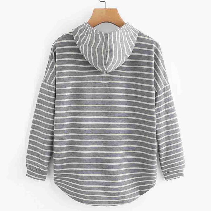 Back view of gray and white striped hoodie with long sleeves hanging on wooden hanger