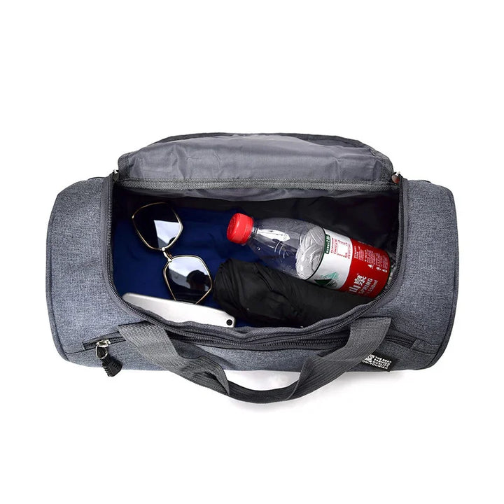 Top view of gray duffel gym bag containing sunglasses, water bottle, umbrella, and smartphone