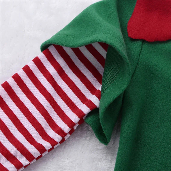 Close-up of red and white striped sleeve under green fabric with red detail on soft white surface