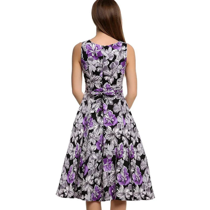 Woman wearing sleeveless black dress with purple and white floral print, back view