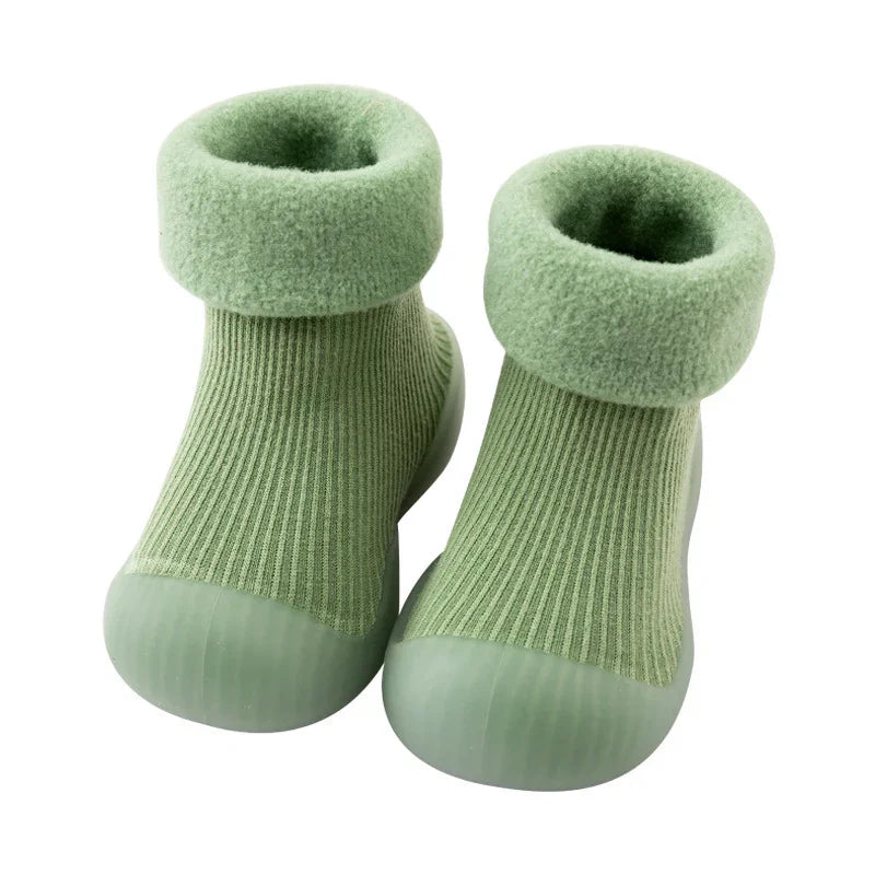 Green toddler socks with foldable fleece cuffs and rubberized sole on white background