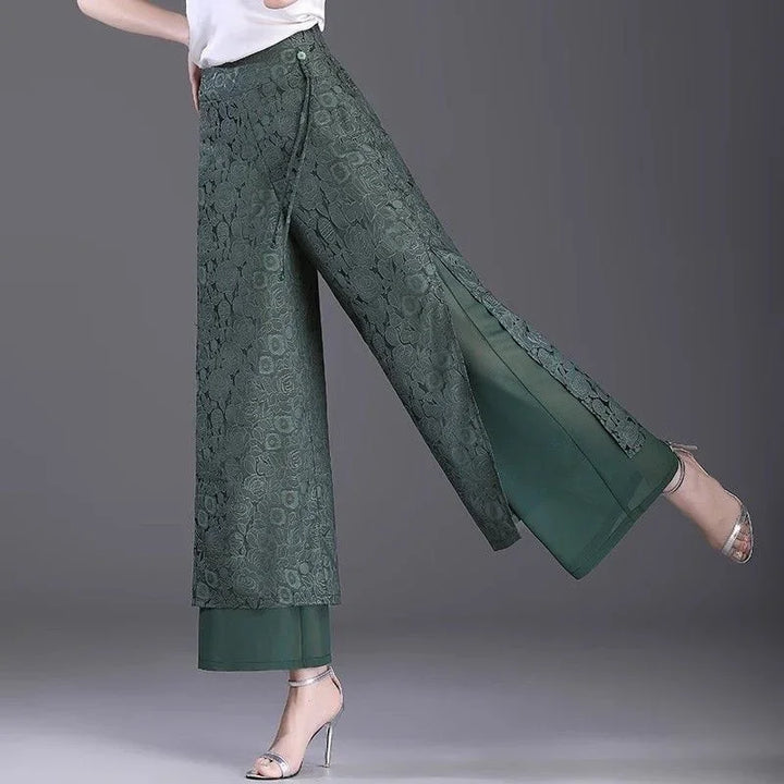 Woman wearing green wide-leg lace overlay pants with inner solid layer and silver heels