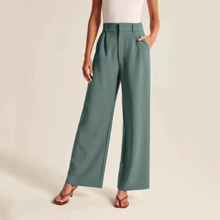 Woman wearing high-waisted wide-leg teal trousers with front pleats and pockets