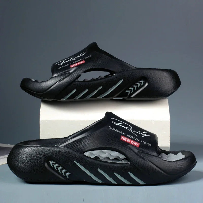 Pair of black summer slide sandals with cushioned soles and printed text on top