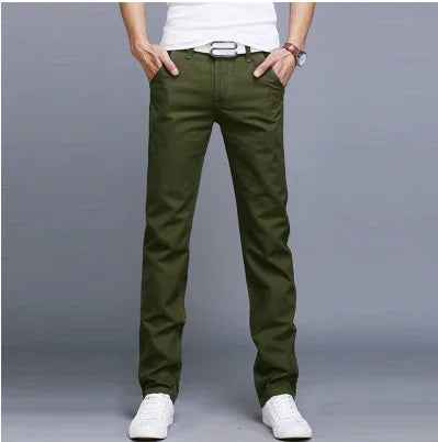 Man wearing olive green slim fit pants with white belt and white sneakers