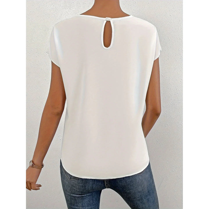 Back view of woman wearing casual white short sleeve top with keyhole button closure and blue jeans