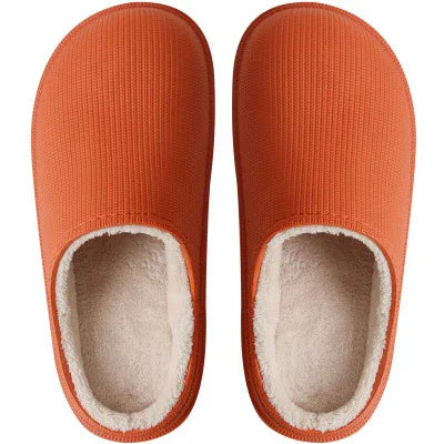 Top view of orange cozy indoor slippers with soft white fleece lining