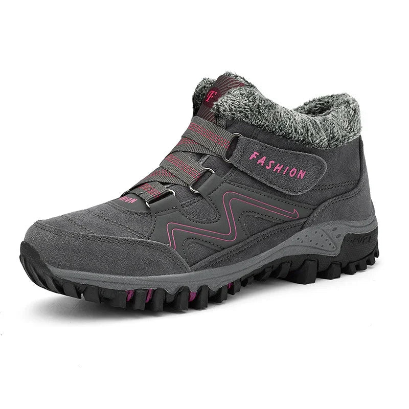 Gray winter hiking boot with faux fur collar, pink accents, and rugged sole for outdoor traction
