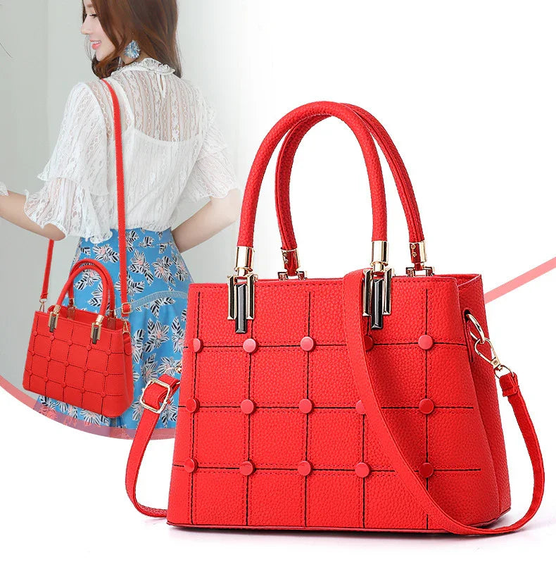 Stylish red leather handbag with top handles and detachable shoulder strap worn by woman in white blouse and floral skirt