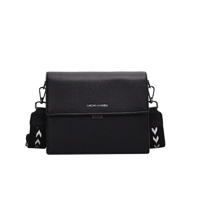 Black textured leather crossbody bag with chevron-patterned adjustable strap