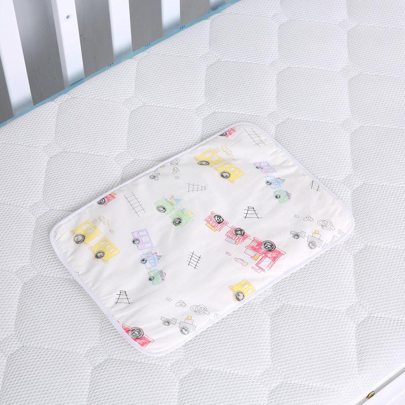 Baby changing pad with colorful train print on white quilted mattress in crib