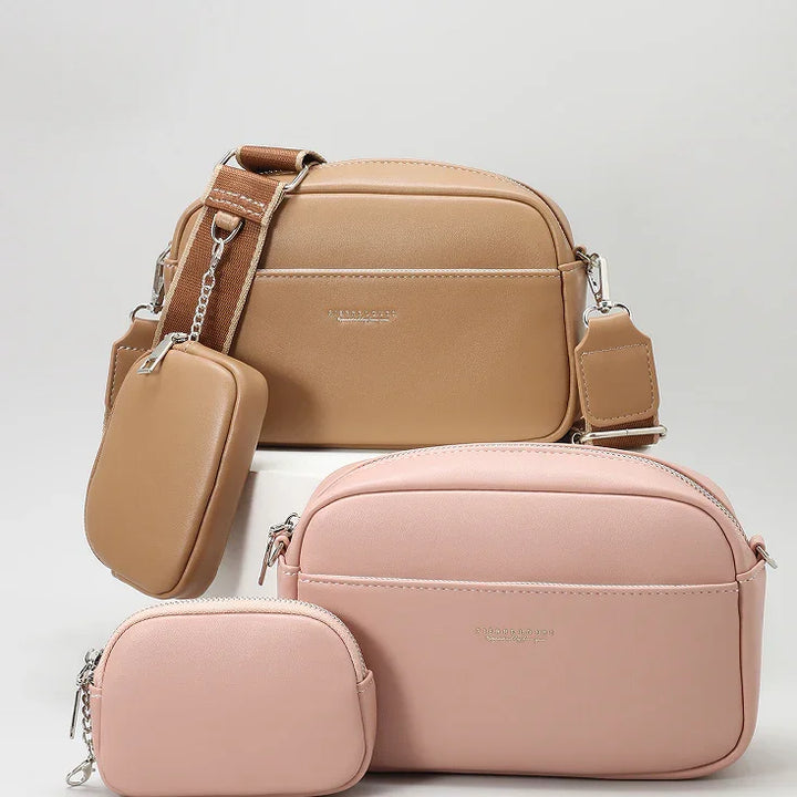 Set of tan and blush pink crossbody bags with detachable coin pouches on plain background