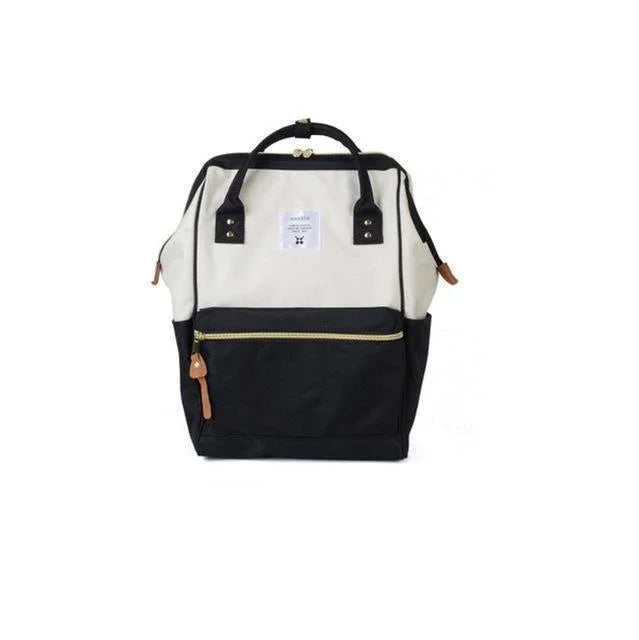 Two-tone black and white backpack with front zipper pocket and leather zipper pull on white background