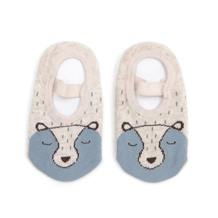 Pair of beige and blue no-show socks with bear face design and elastic straps on white background