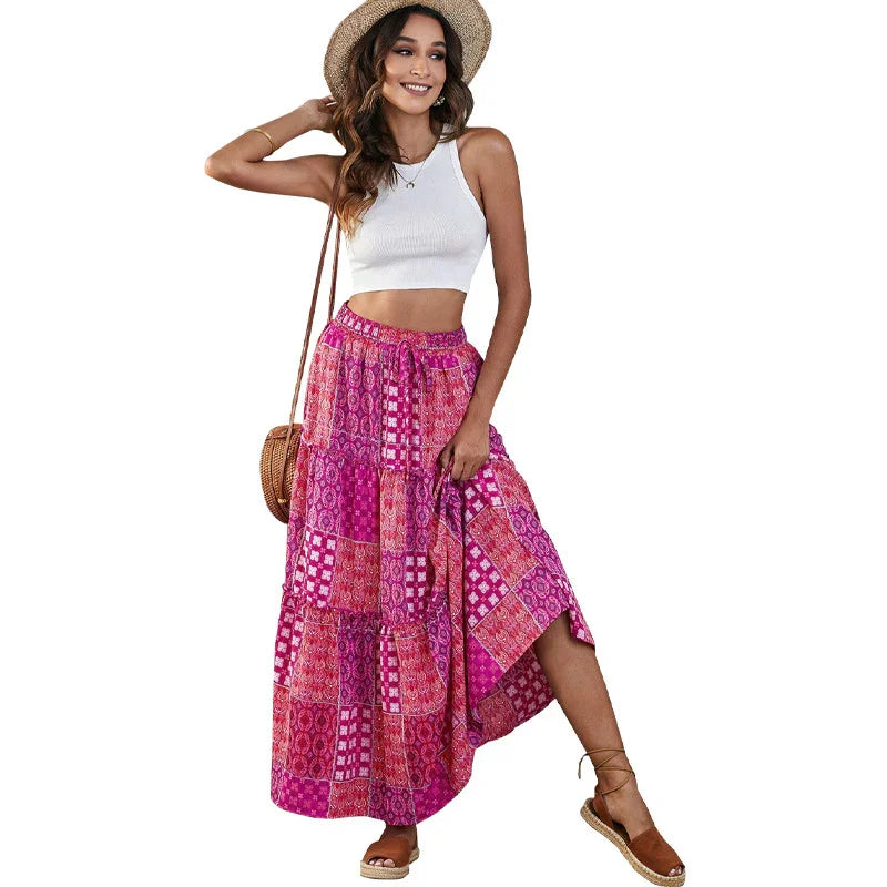 Woman wearing a white crop top and pink patchwork maxi skirt with a straw hat and brown espadrille sandals