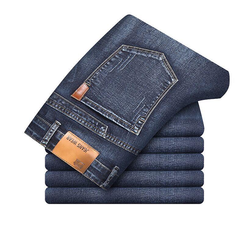 Stack of neatly folded dark blue denim jeans with visible back pocket and leather patch labeled Jeans Wear