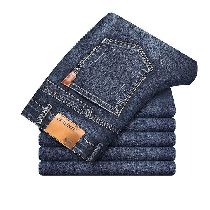 Stack of neatly folded dark blue denim jeans with visible back pocket and leather patch labeled Jeans Wear