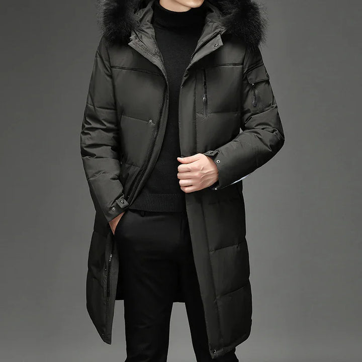 Man wearing long black padded winter coat with fur hood and black turtleneck sweater