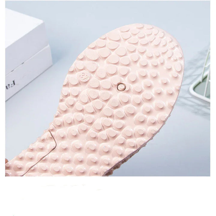 Close-up of pink textured sole of massage slippers with raised bumps for foot stimulation