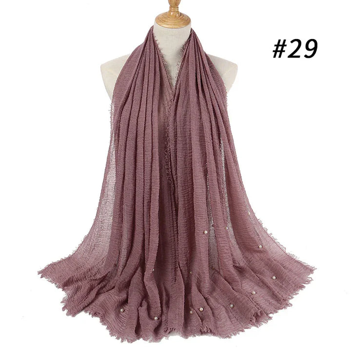 Mauve crinkled textured scarf with small pearl accents displayed on mannequin