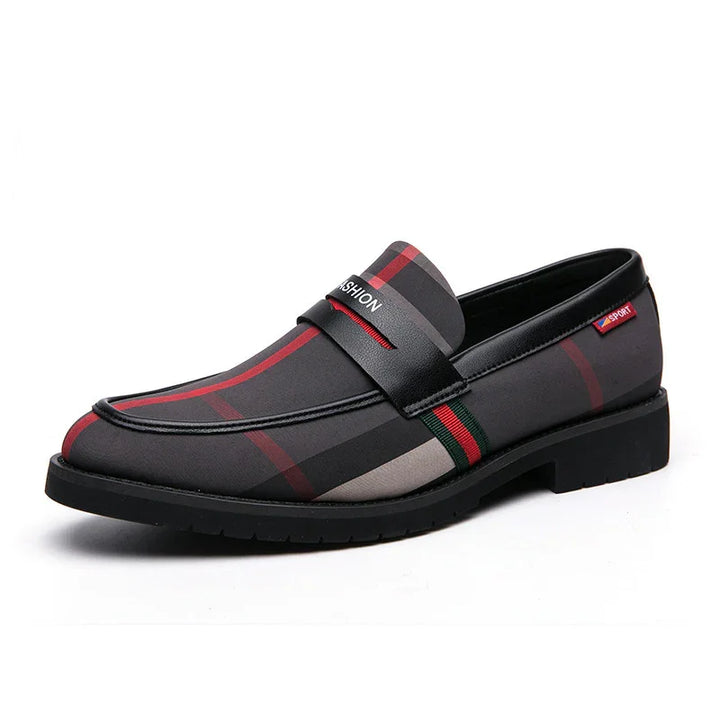 Men's black and red plaid slip-on loafer with leather strap and rubber sole on white background