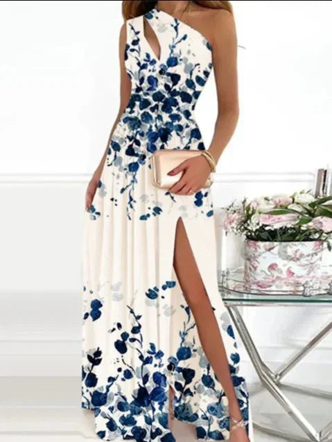 Woman wearing white floral maxi dress with blue flowers and thigh-high slit holding beige clutch