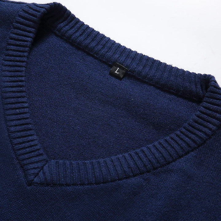 Close-up of navy blue V-neck sweater collar with ribbed trim and size L tag on white background