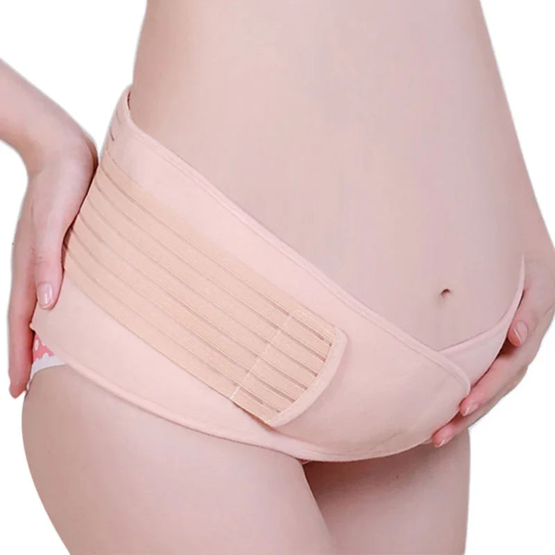 Pregnant woman wearing a beige maternity support belt around her baby bump