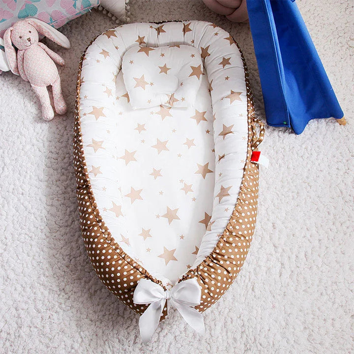 Baby nest with white and brown star pattern, polka dot border, and white bow on beige carpet