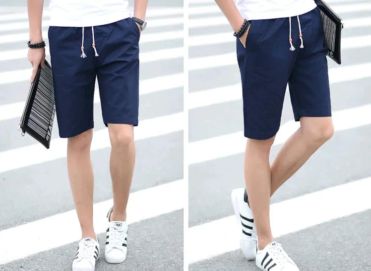 Front and side views of man wearing navy blue casual shorts with white drawstrings paired with white Adidas sneakers