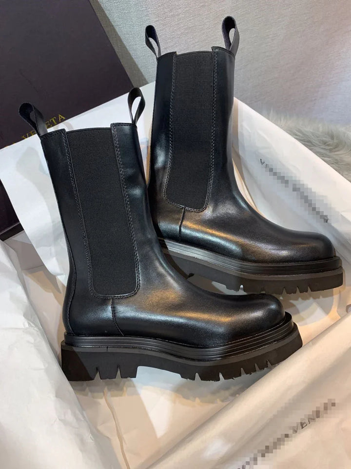 Black leather chunky platform Chelsea boots with elastic side panels on white paper