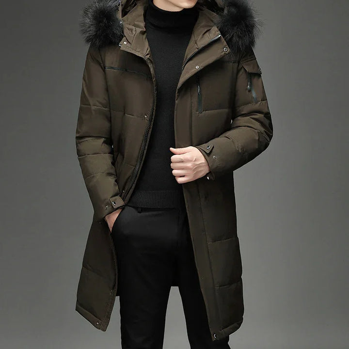 Man wearing dark olive green long winter parka with black fur hood and black turtleneck sweater