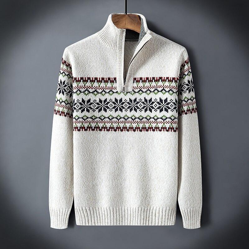 Cream knit sweater with half zipper and black, green, maroon snowflake pattern across chest and sleeves