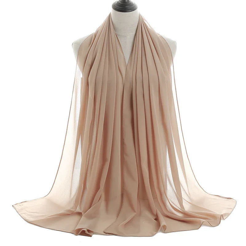 Light beige chiffon scarf displayed on mannequin with pleated texture and flowing fabric