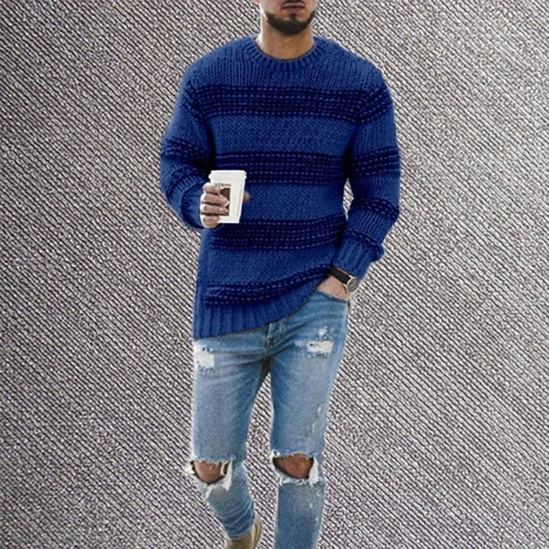 Man wearing blue striped knit sweater and ripped light blue jeans holding coffee cup