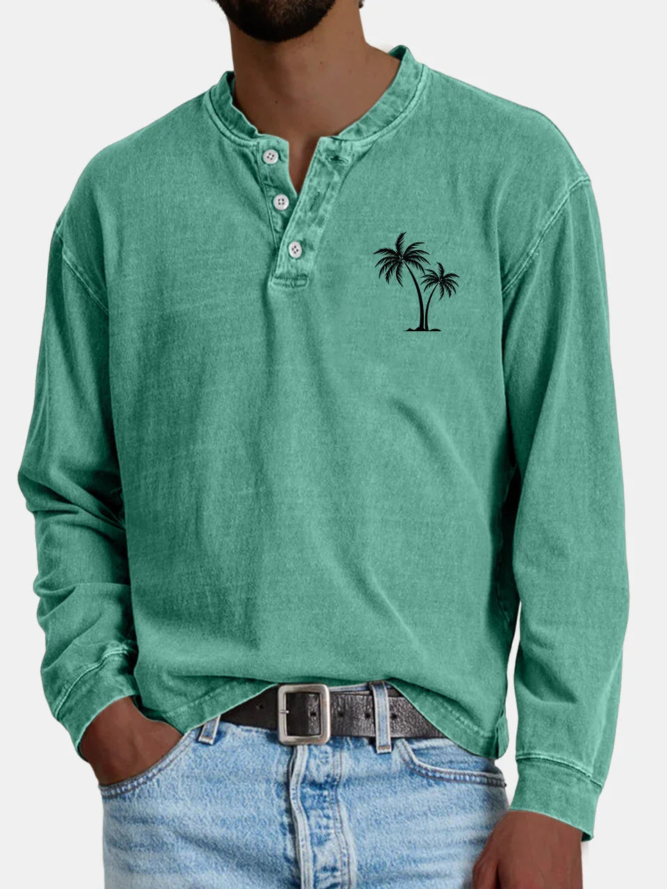 Men's casual green long-sleeve henley shirt with palm tree graphic and light blue jeans
