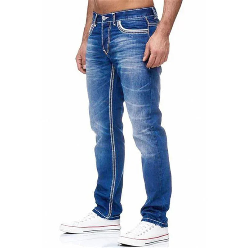 men's blue denim jeans with white stitching details worn with white sneakers on white background