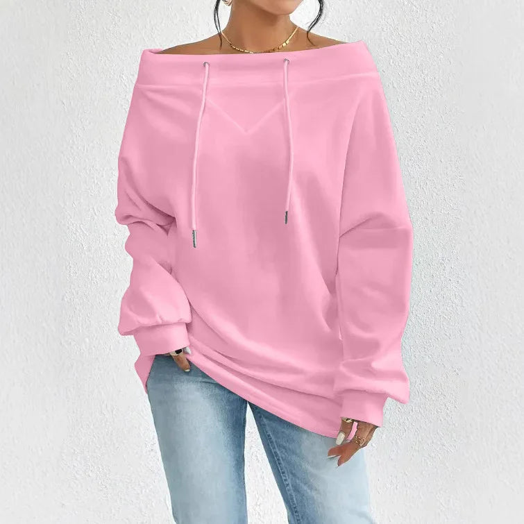 Woman wearing pink off-shoulder hoodie with drawstrings paired with light blue jeans