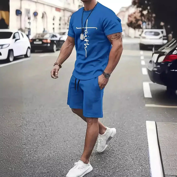 Man in blue athletic shorts and t-shirt with faith print walking on street wearing white sneakers